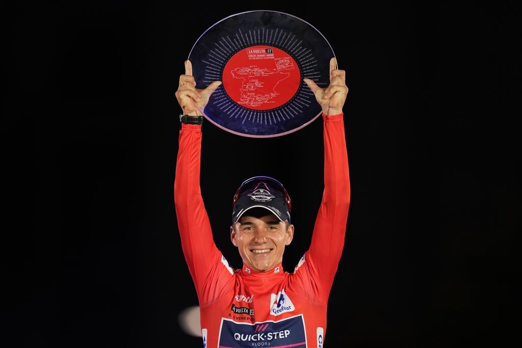 FILE - Belgian Remco Evenepoel of Quick-Step Alpha Vinyl holds up his trophy on the podium after winning La Vuelta cycling race in Madrid, Spain, Sunday, Sept. 11, 2022. Remco Evenepoel could hardly face a tougher lineup of challengers to his Spanish Vuelta title defense when the three-week race kicks of in Barcelona on Saturday, Aug. 26, 2023. (AP Photo/Manu Fernandez, File)